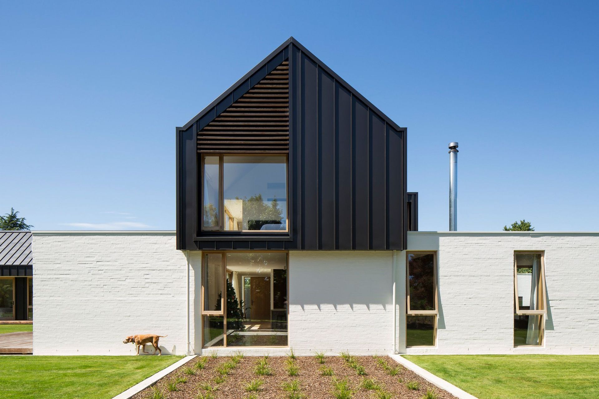 Vertical windows break up rhythm along the edge of the main living area. The upper storey glazing features a cedar screen to bring dappled light into the master suite.