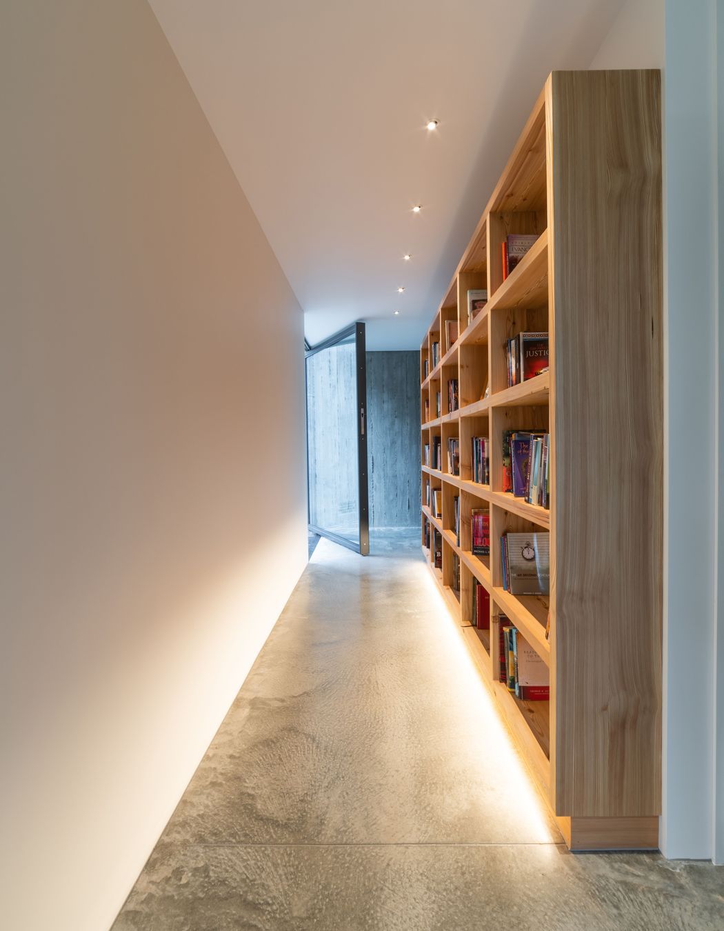 The glass entry door allows for seamless sightlines throughout the house to the cliff face behind.