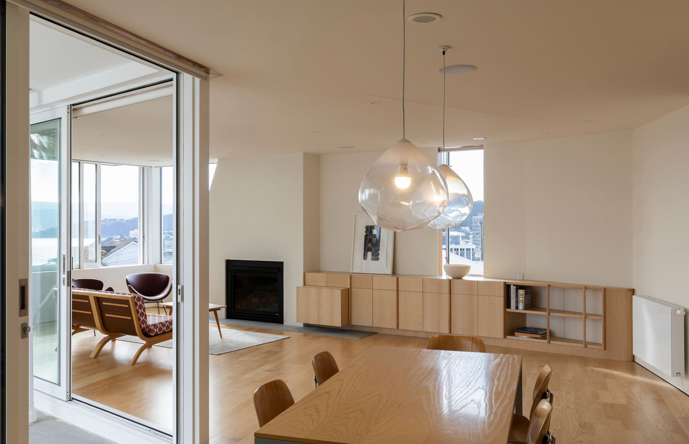 The living area of the downstairs apartment leads out to a terrace on the left and features views over Wellington Harbour.