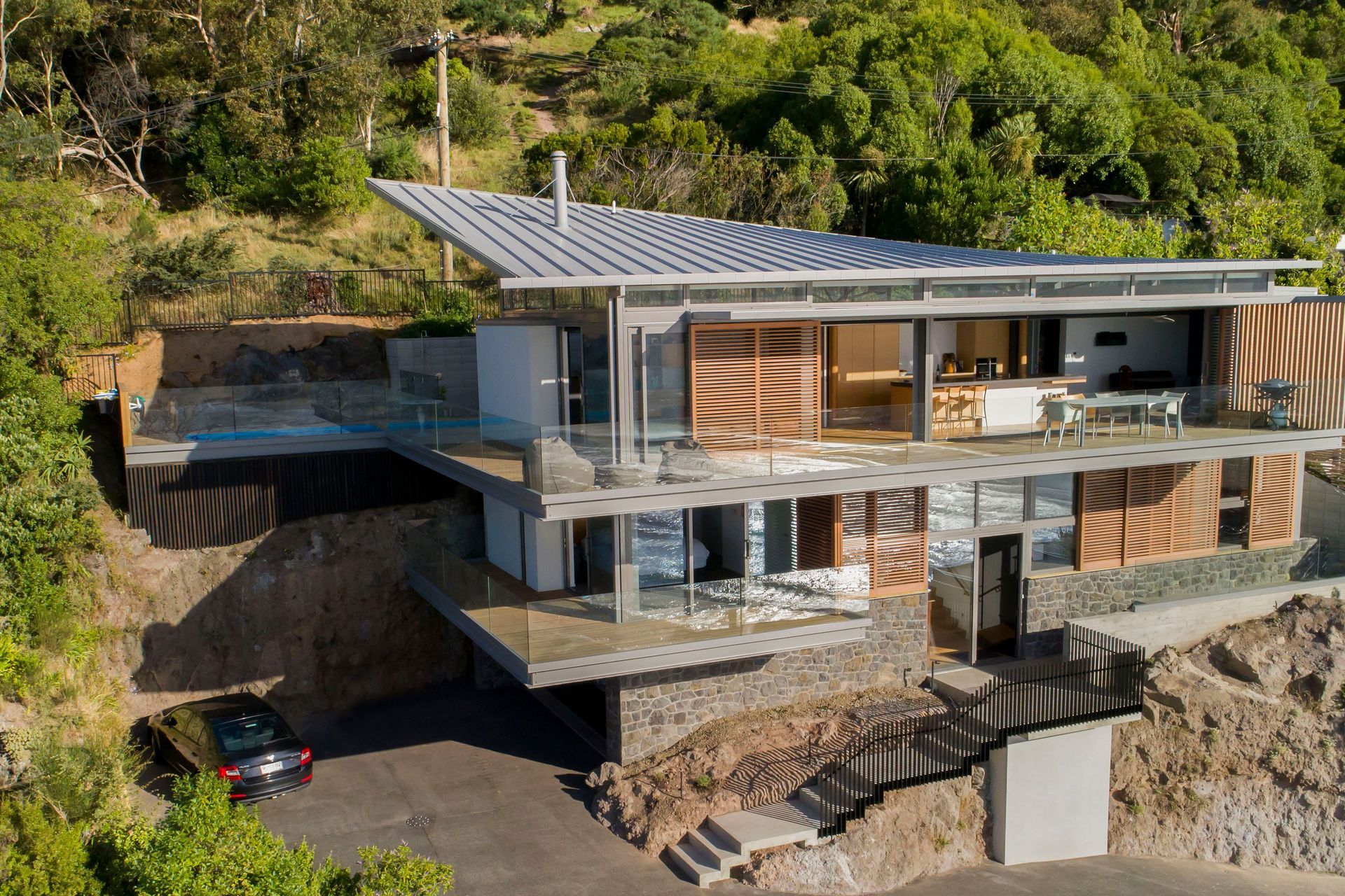 While the house appears to emerge directly from the rock, it is in fact sitting free of the cliff face, a condition of the building consent.
