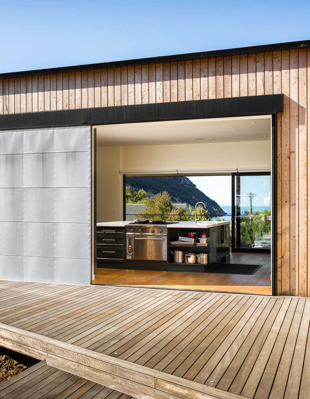 The industrial door opens up the 'evening' deck to a view of the ocean.
