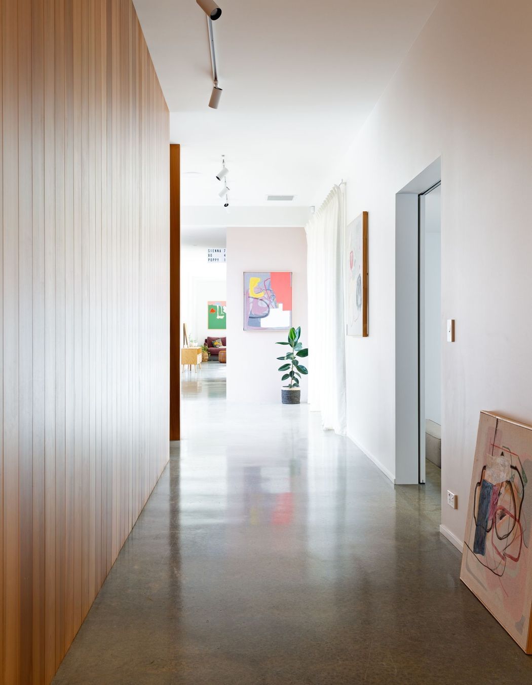 The gallery-like hallway showcases the owners' artworks.
