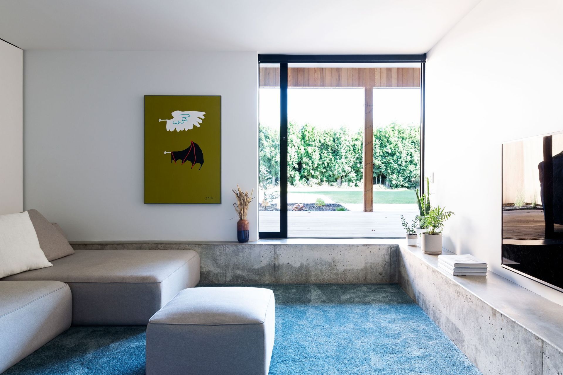 The sunken lounge features built-in concrete seating, exposing some of the structure of the home.