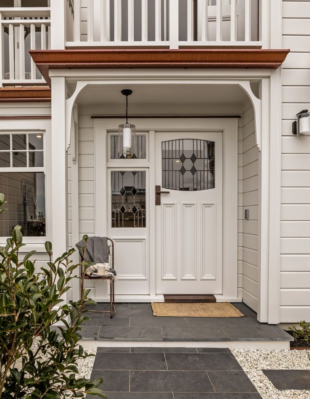 The front entrance is tiled in basalt and features stained glass windows to match the original house.