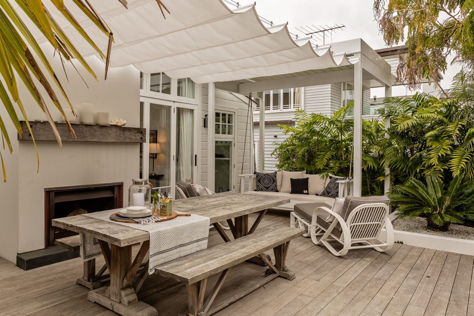 A decked outdoor room with fireplace on the rear of the home.