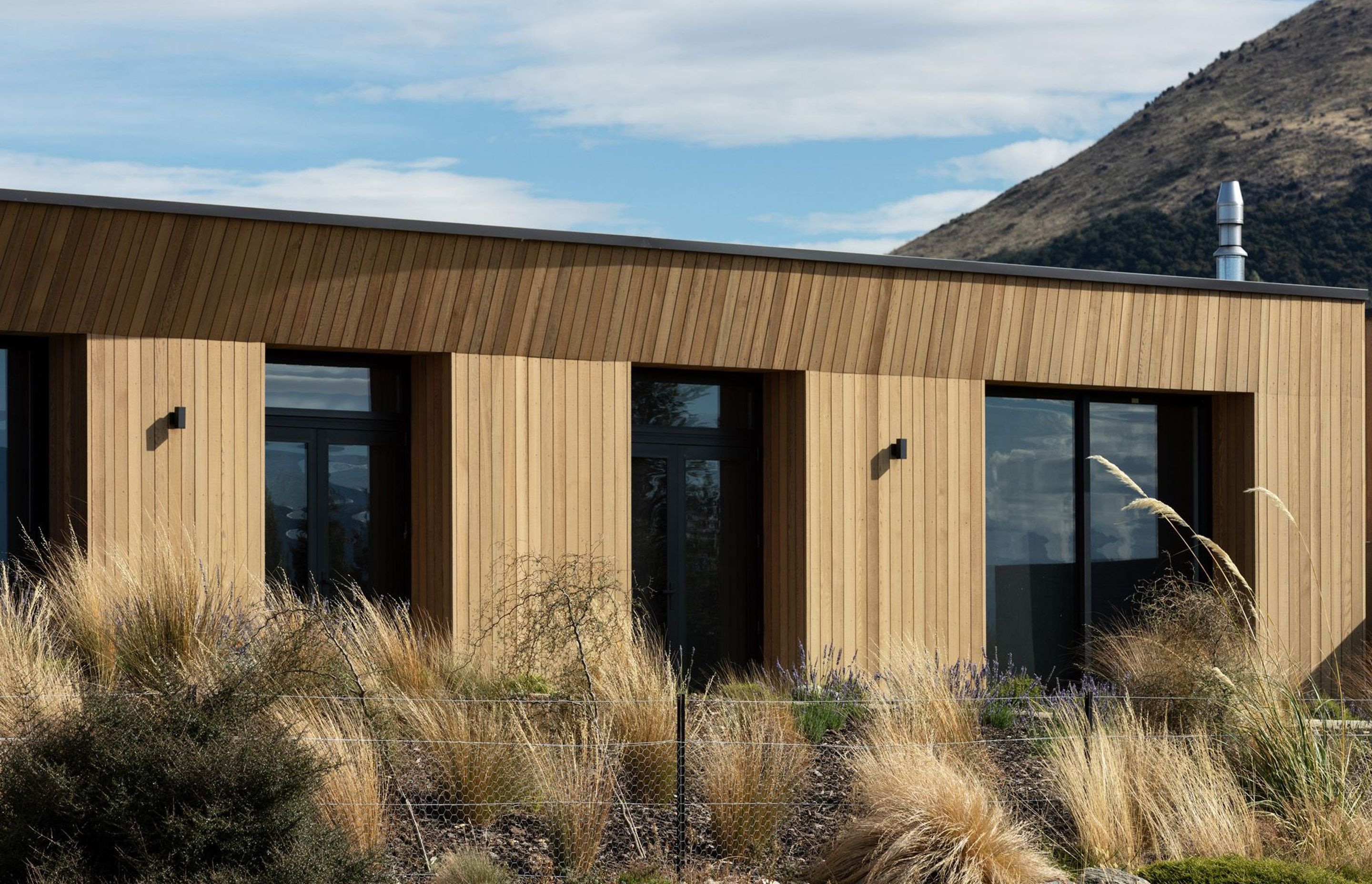 Angled timber cladding and deep, recessed windows provide shelter from the sun during the hot Otago summers.
