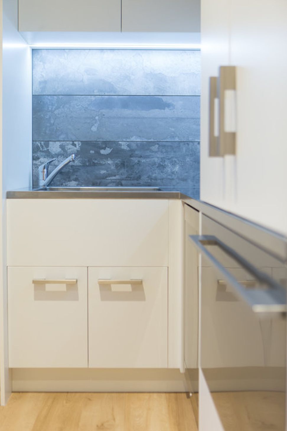 Strong stone splashback is paired with a deep stainless laundry sink.