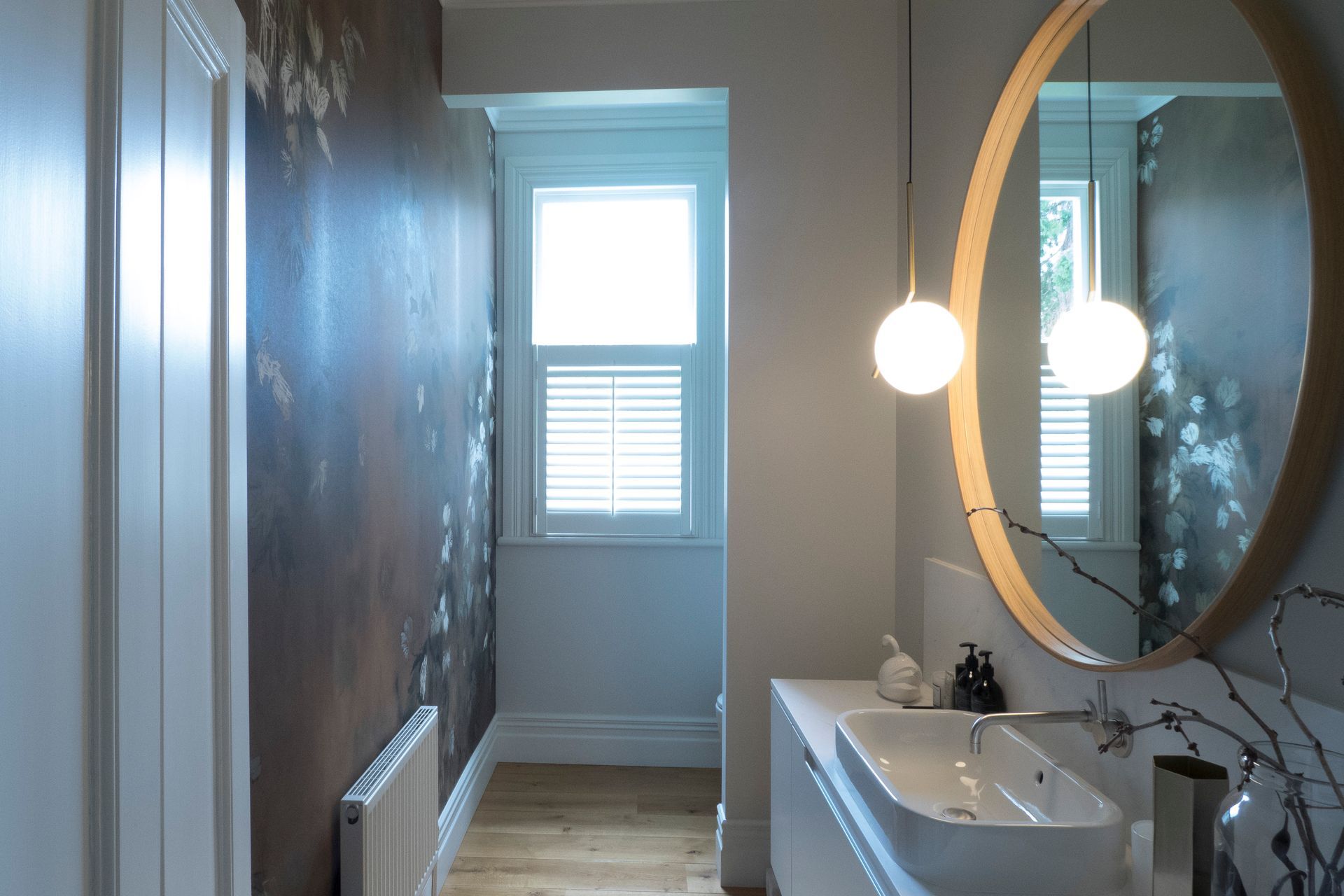 Guest Bathroom featuring stunning wallpaper reflected in mirror.