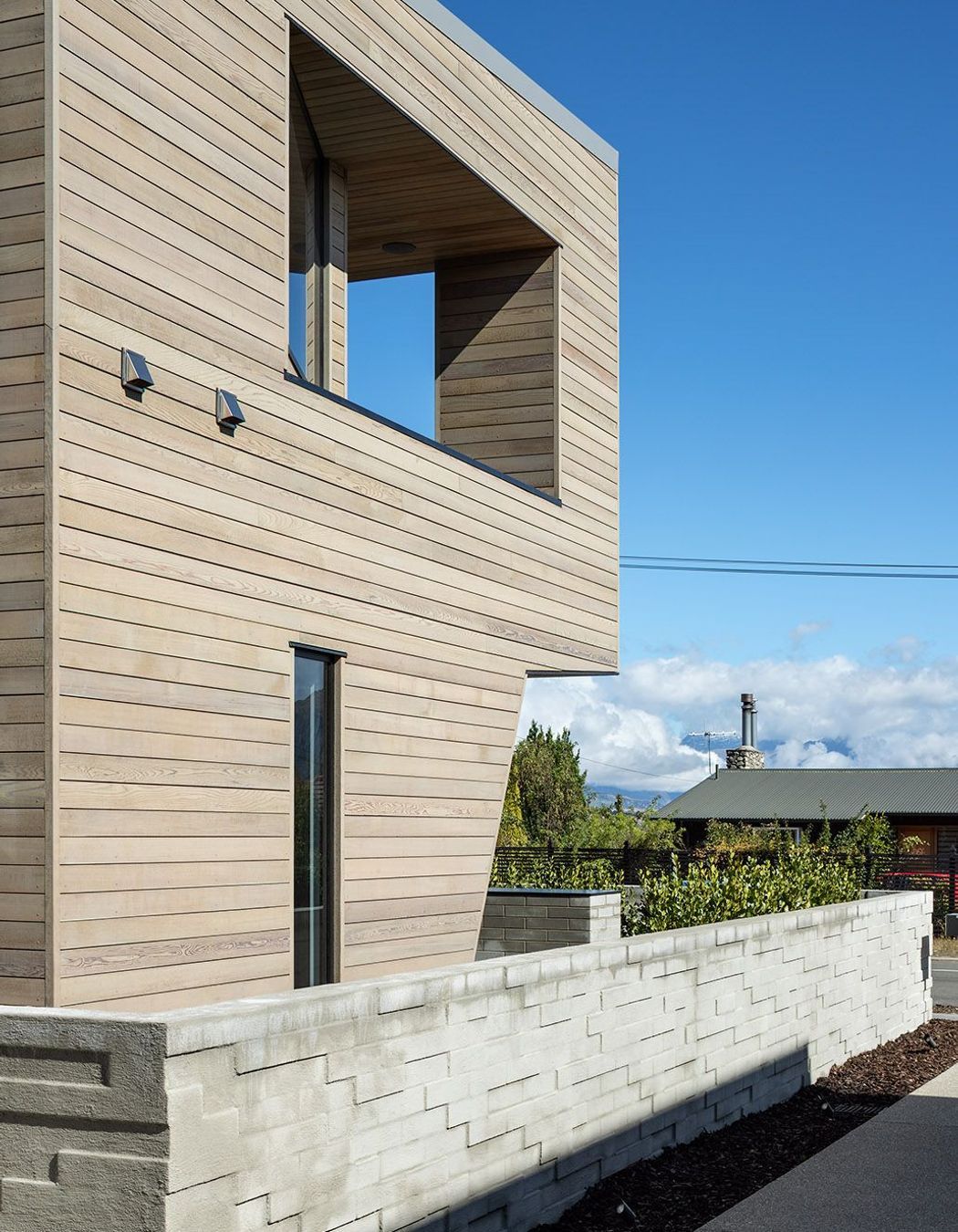 The exterior wall in half-width concrete blocks has been arranged haphardly to create a textural surface.