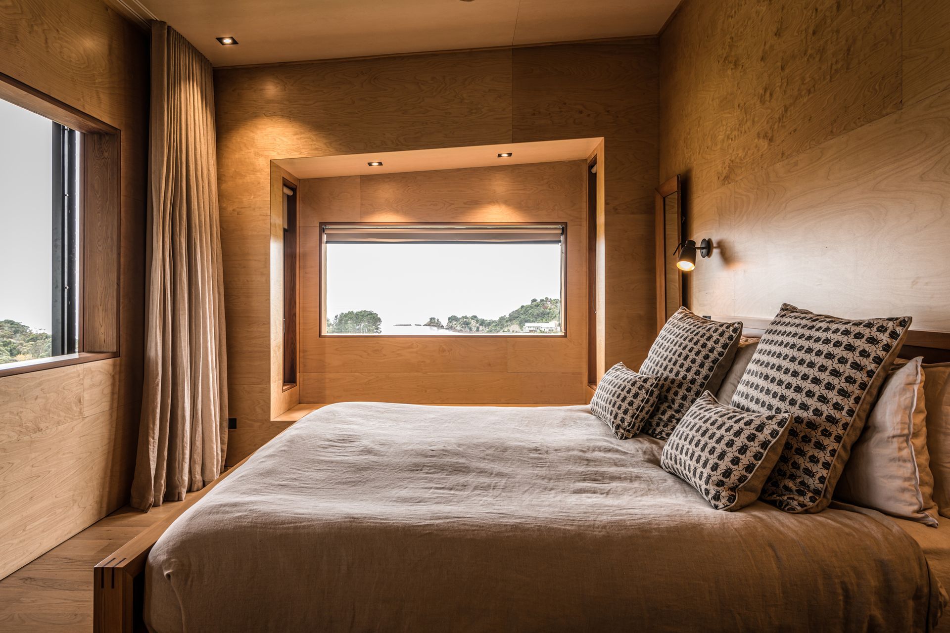 The master bedroom features ocean views and a sliding window that overlooks a second lounge, a library and a study. Photograph by ArchiPro.