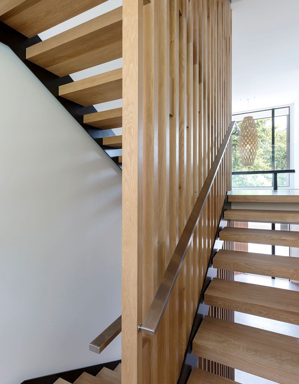 An American white oak timber stairwell links three storeys of the house.