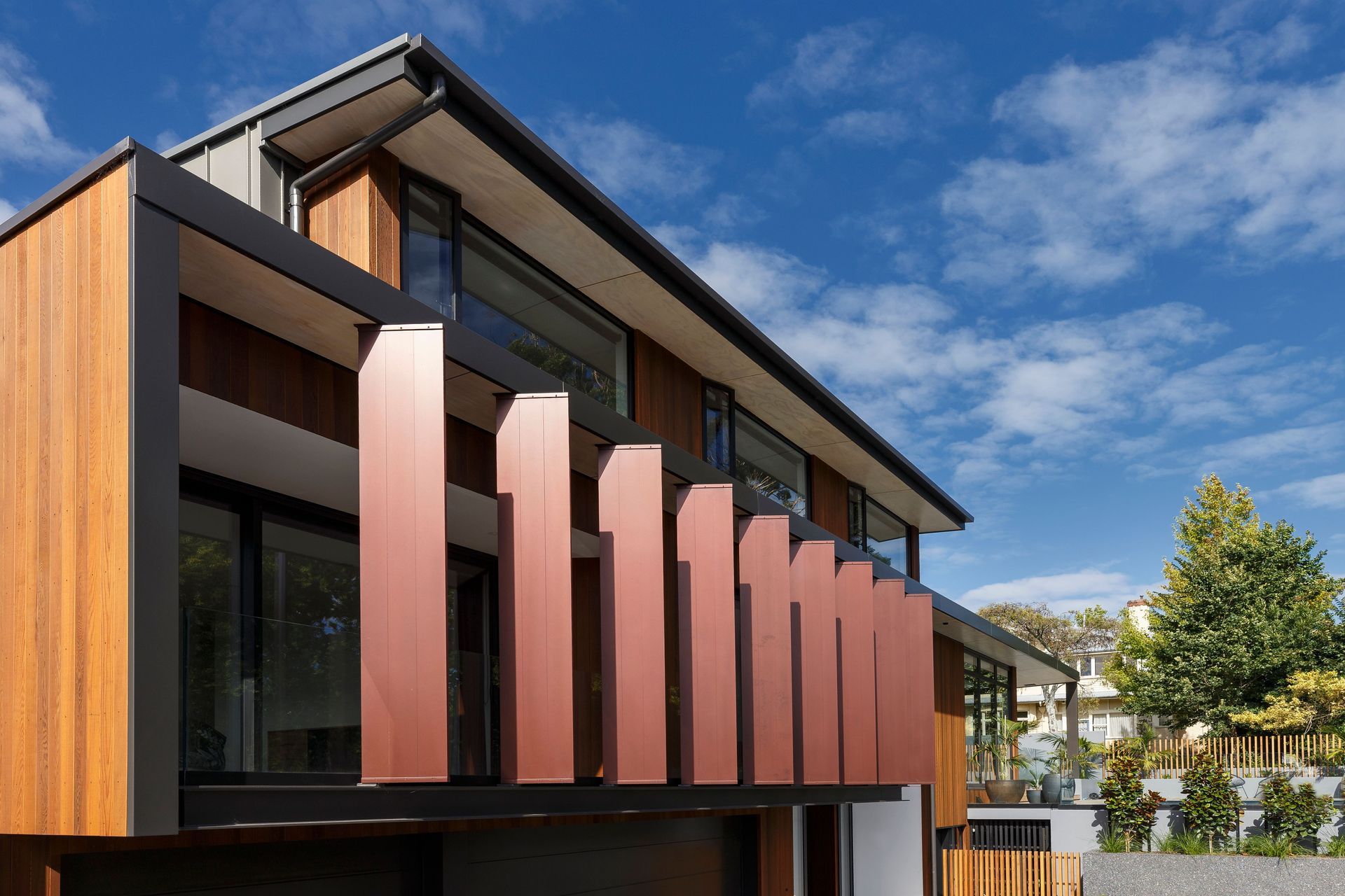 The exterior view of the front fins, painted in liquid copper to complement the warm tones of the cedar cladding.