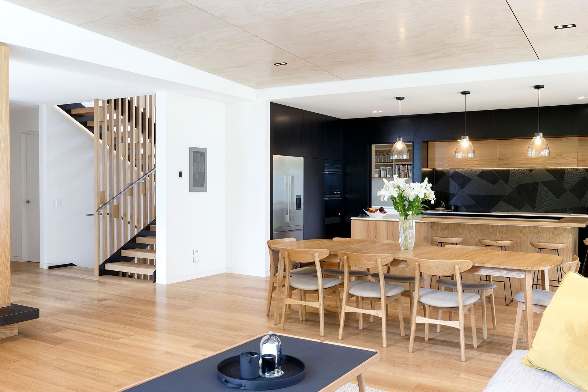 The view from the lounge towards the feature staircase, kitchen and dining area.