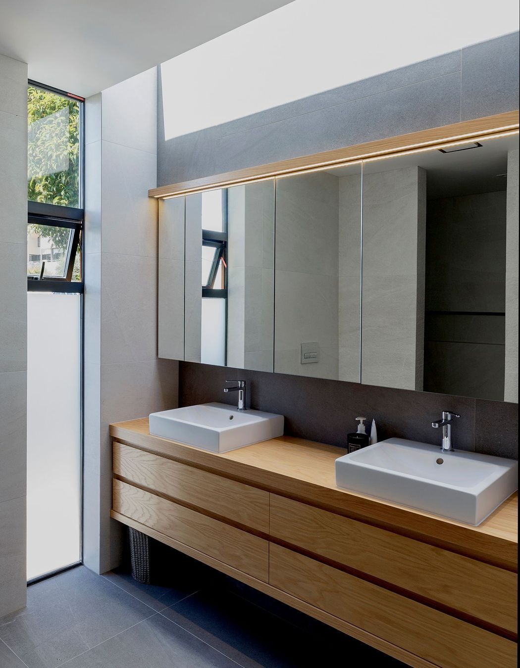 The bathroom features a clerestory window for extra light and robust basalt flooring tiles.
