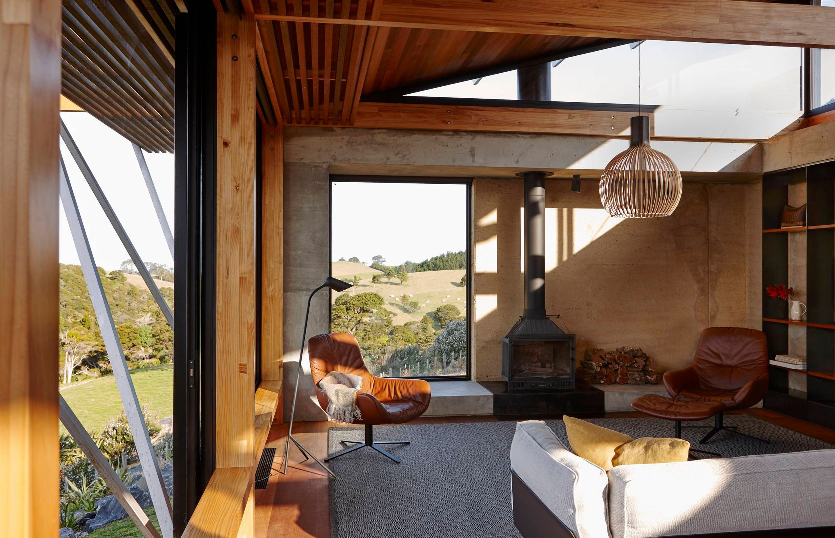 The rammed earth wall is exposed on the interior of the lounge, adding a strong earthy contrast to the timber and glass. Photograph by Jackie Meiring.