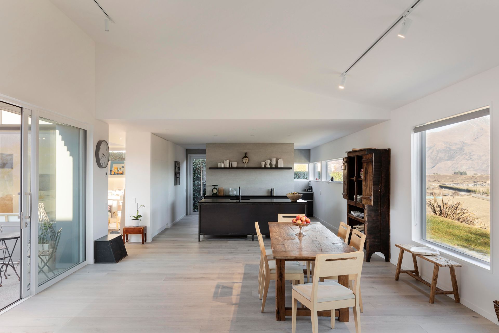 The kitchen hides a scullery behind it, removing clutter from the open-plan kitchen/dining space.