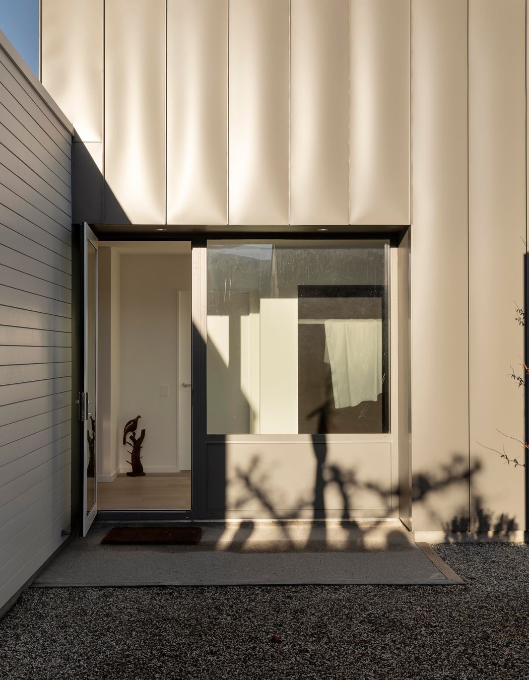 The intersection between the white and grey parts of the house is seamless and throws interesting shadows across the building.