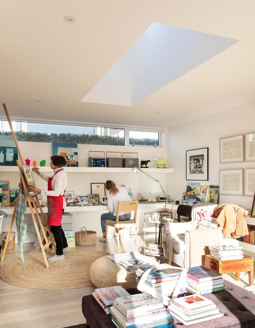 Jane painting in her studio, with her daughter working alongside.