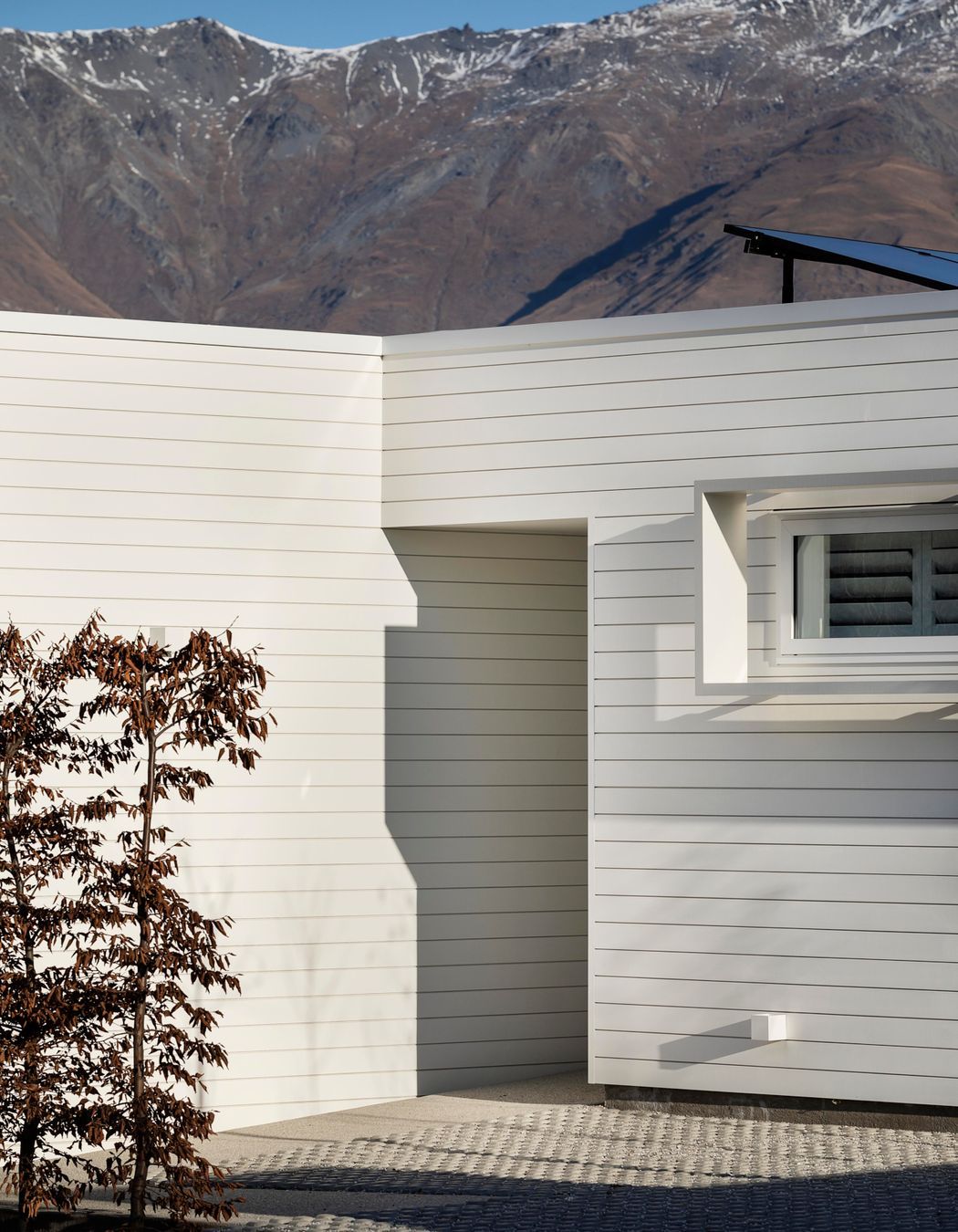 The entry is humble in scale and recessed into the house for privacy.