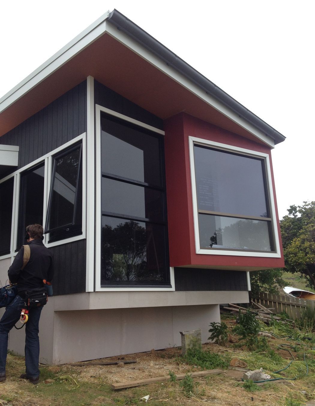 Materials are robust. Ecoply shadow clad v-joint board, with harries vero board (floor had to be enclosed for BAL requirements). Builder put the gutter on the front of the cottage, without instruction, between site visits. Colours are taken from the landscape-charcoal of the basalt of The Nut, red for the iron rich soil