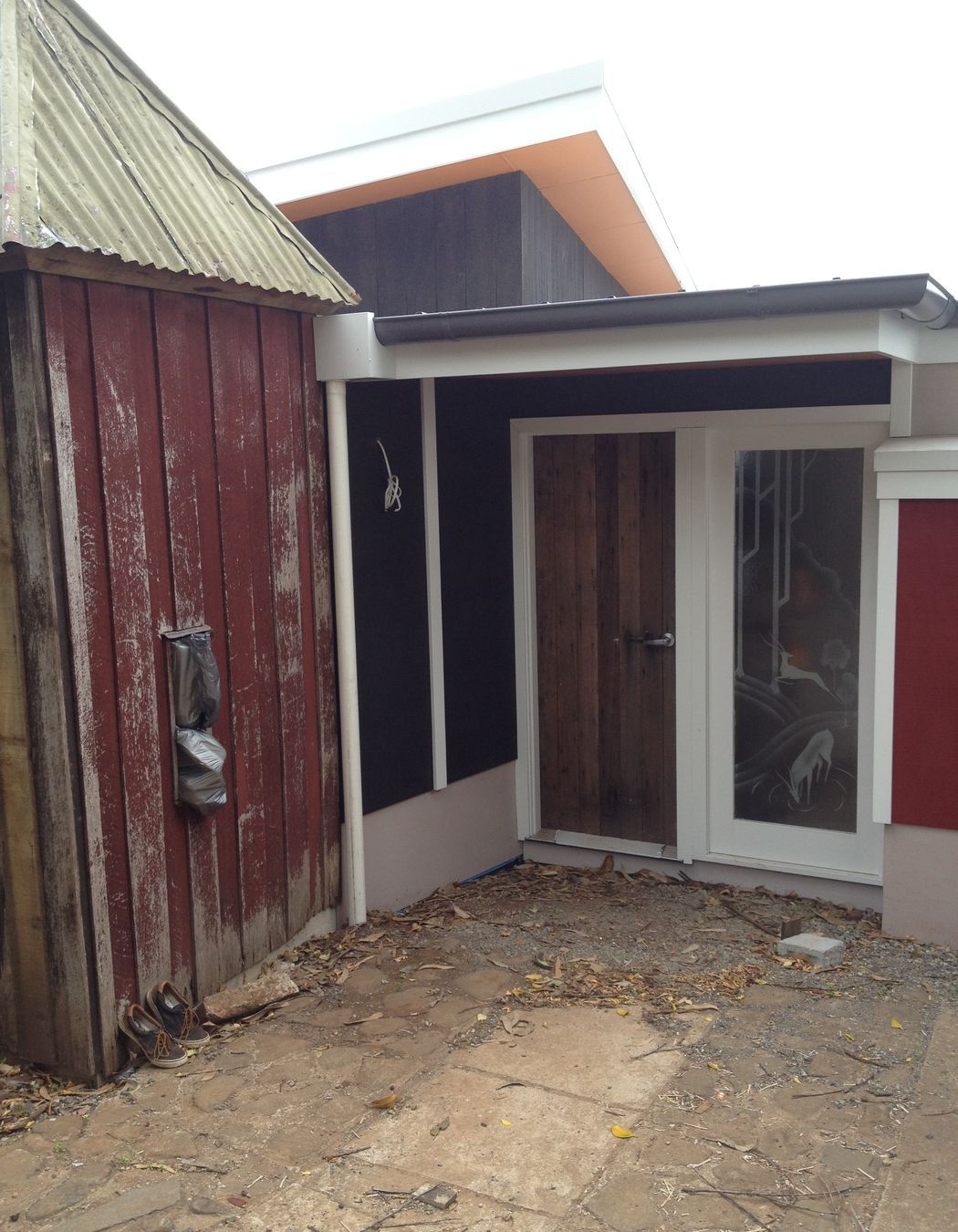 Entry door from The Fishermans Association Hut, salvage art deco 'mountain deer' motif acid etched doors as sidelights (protective 3m film to flat side for safety), original duck shed, now guest wc, was removed during construction and re-erected on new slab .
