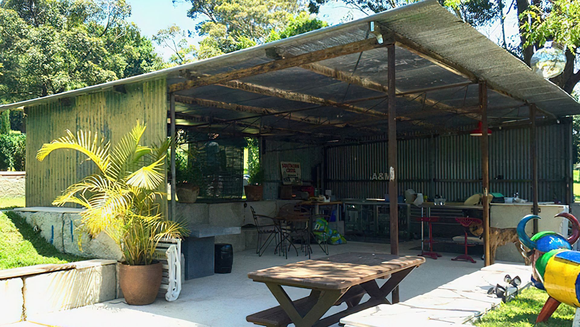 Lakeside entertainment house made from relocated patinated farm shed, mounted on concrete waste blocks