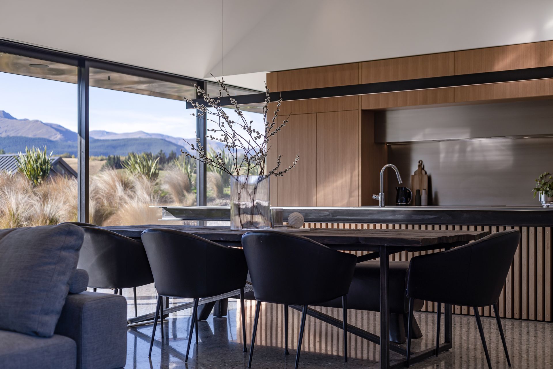 Oak cabinetry and stainless steel feature in the kitchen, with a cantilevered beam light over the island bench.