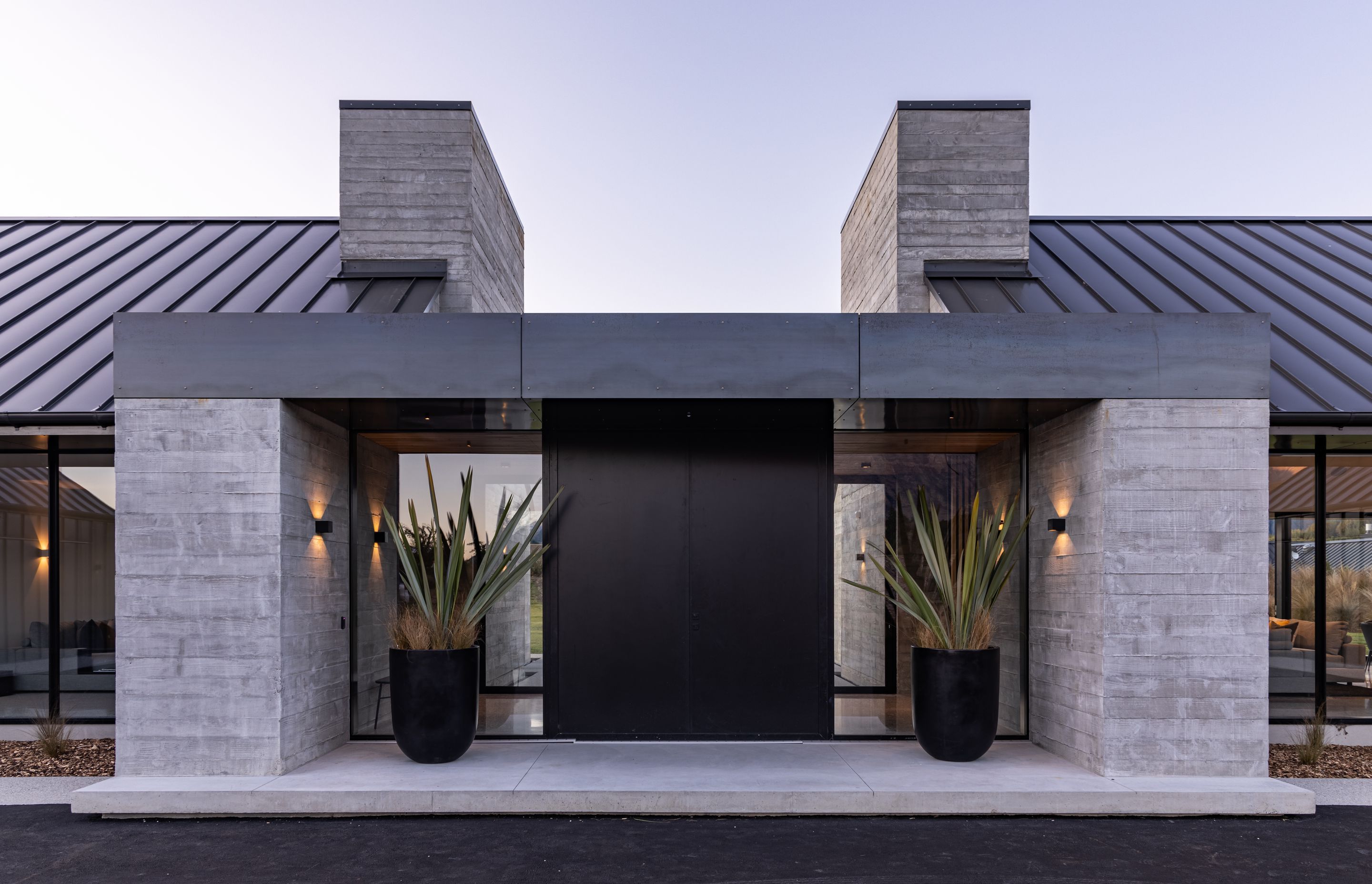 The entrance is centred, a large pivot door welcoming visitors to the home.