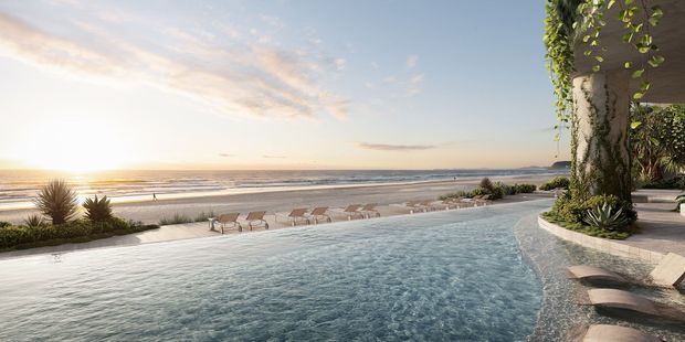 A panoramic coastal resort-style outdoor scene at sunset, featuring a curving infinity pool in the foreground, a sandy beach and ocean beyond, and a planted terrace with loungers and lush vertical greenery along the right edge. The composition is serene and luxurious, with warm evening light and uninterrupted beachfront views.