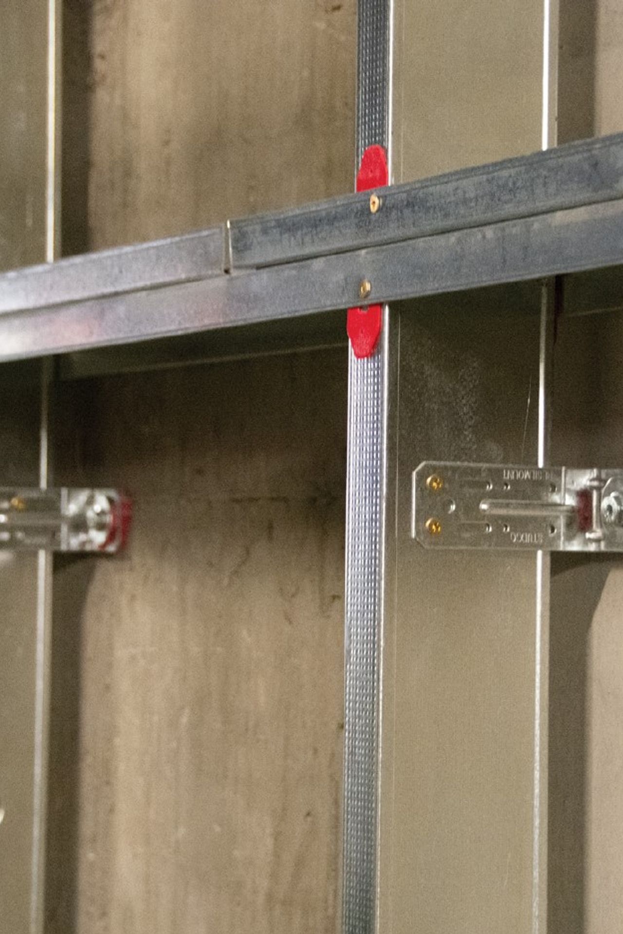 The M48R Right Angle Resilient Mount Bracket fixed to a stud for sound isolation purposes.