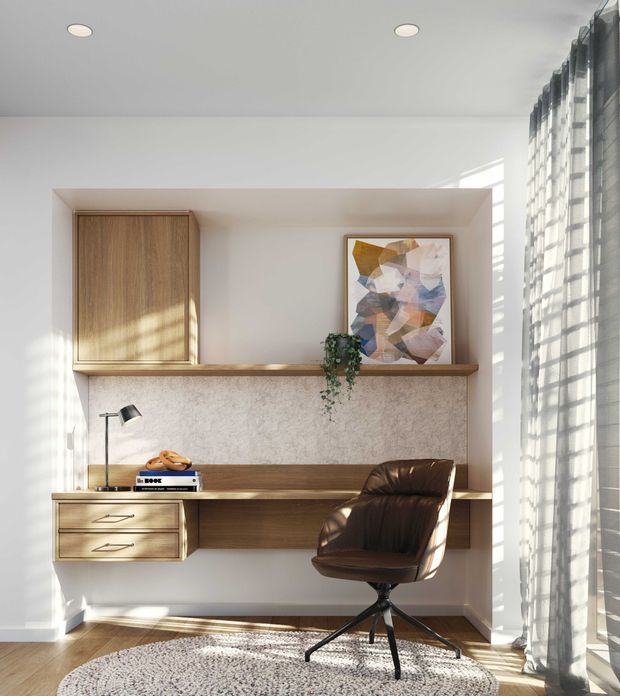 Bright, compact home office with a built-in timber desk and shelving wall, integrated drawers, a wood-fronted overhead cabinet, and a textured pale backsplash or wall panel. A leather swivel chair sits on a round textured rug, with a desk lamp, books, artwork, and trailing plant adding detail. Strong sunlight filters through full-height sheer curtains and casts striped shadows across the room.