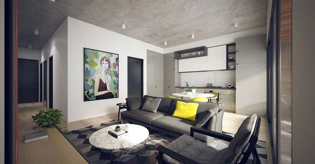 A compact open-plan apartment interior combining a living room and kitchen. The room features a dark grey sofa and armchairs, a round white coffee table, geometric patterned rug, bright yellow accent cushion, minimalist white kitchen cabinetry, dark splashback, integrated appliances, polished concrete-style ceiling, and a large framed artwork. A hallway is visible to the left and timber-toned built-in joinery frames the right side.