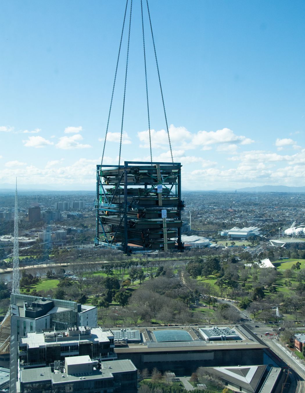 A delivery of steel being lifted to an upper level.