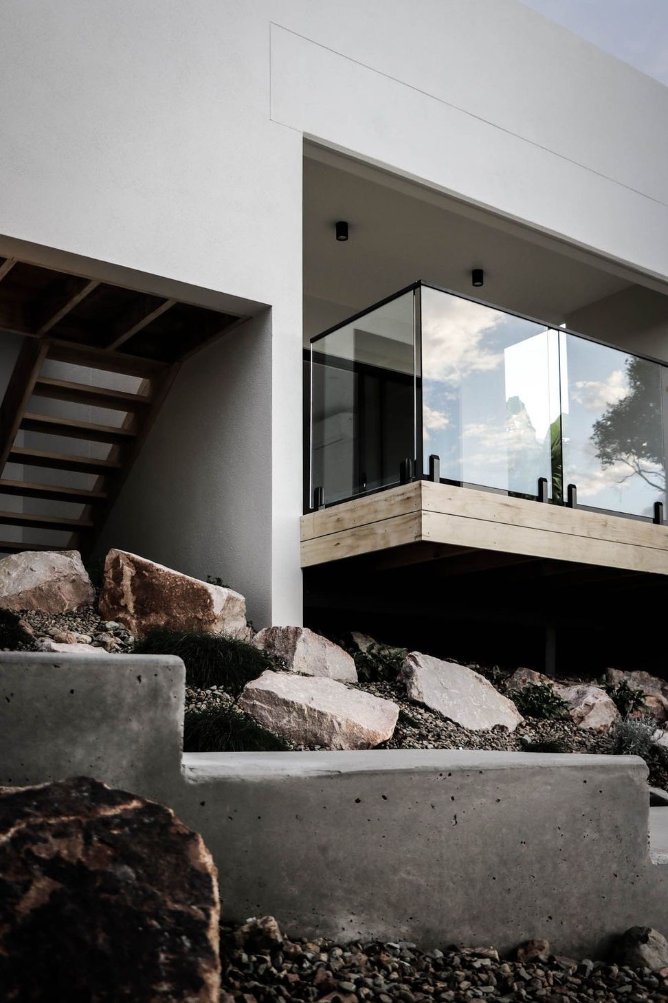 Anderson Residence - Exterior. Cantilevered white volume above the boulder garden.
