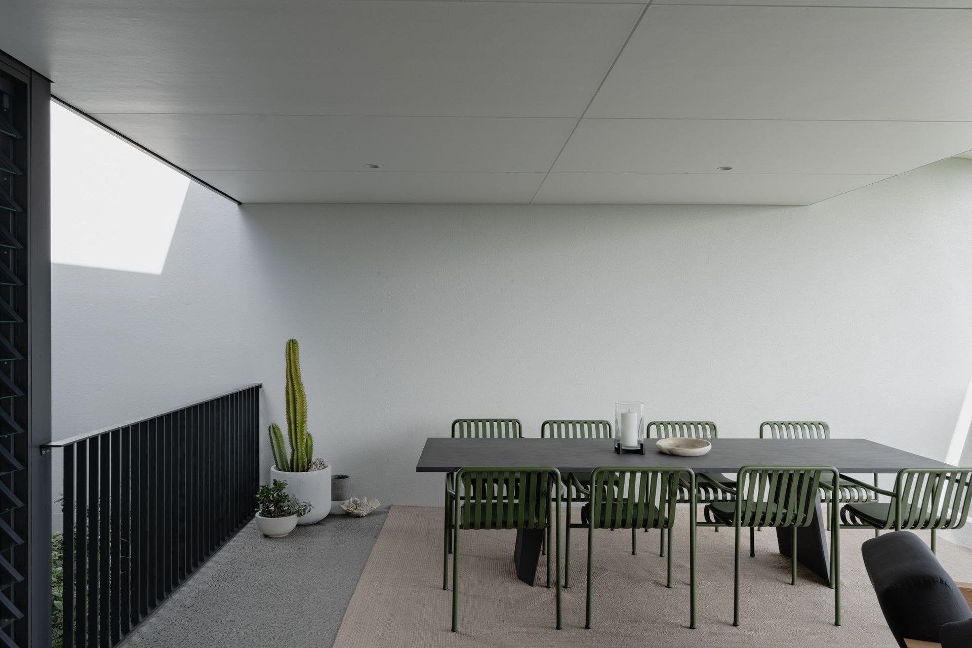 The Dual House - Dining Room. Dining area beneath a skylight beside the balcony.