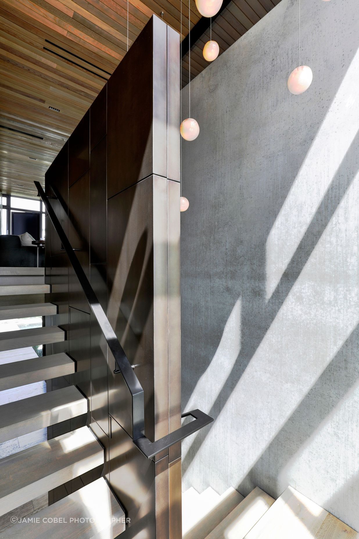 The travertine stairs juxtapose against the bronze wall lining.