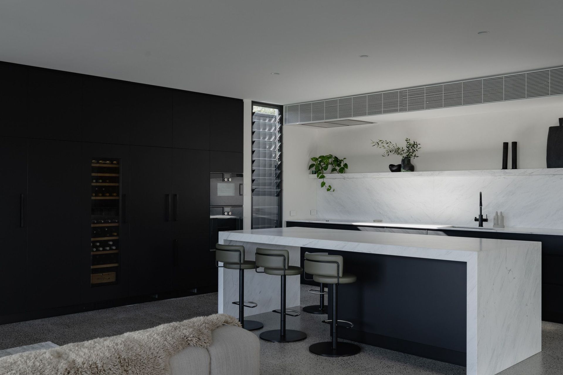 The Dual House - Kitchen. Black joinery with a white stone island bench.