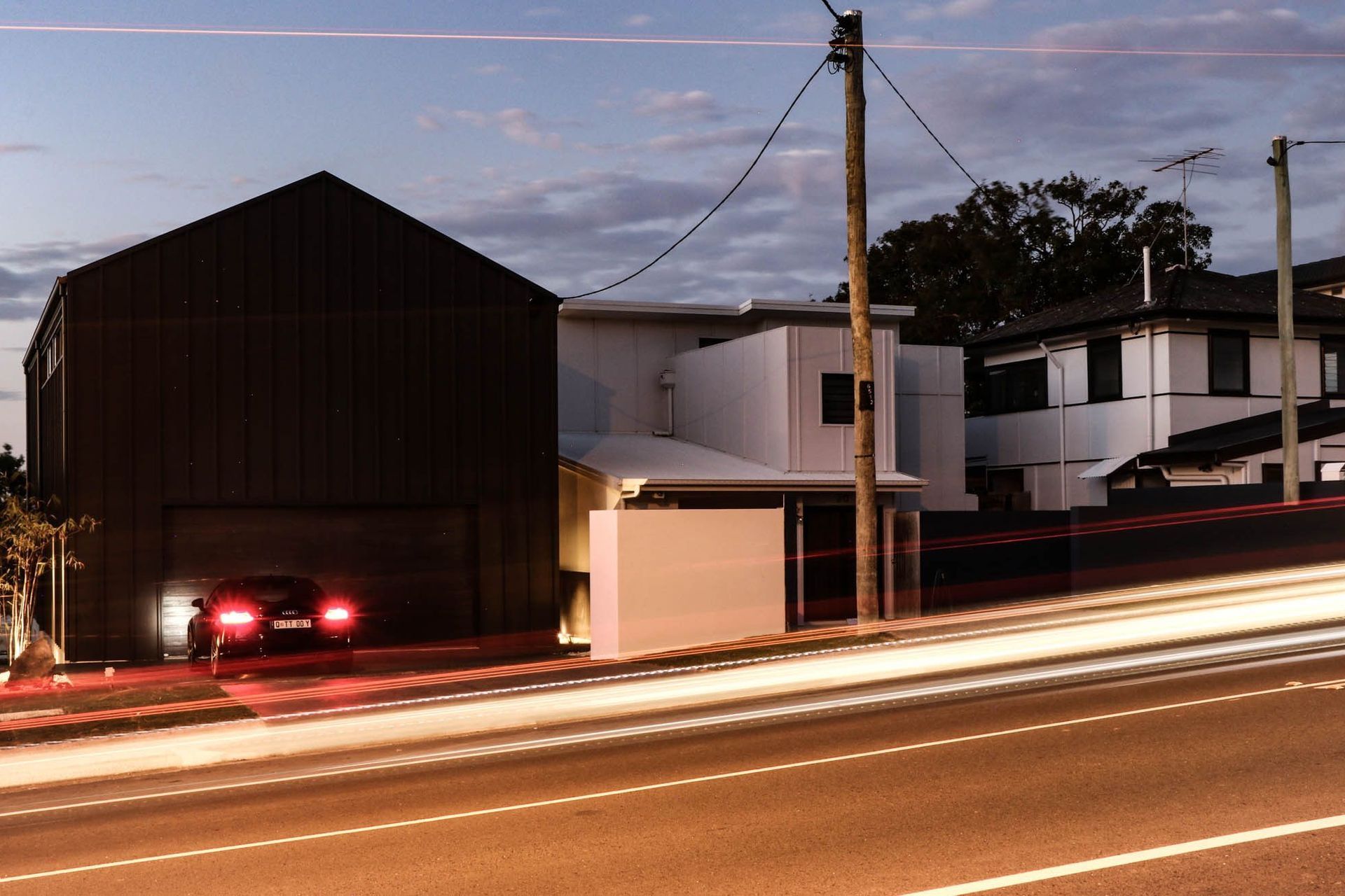 Anderson Residence - Exterior. Street frontage at dusk with passing light trails.