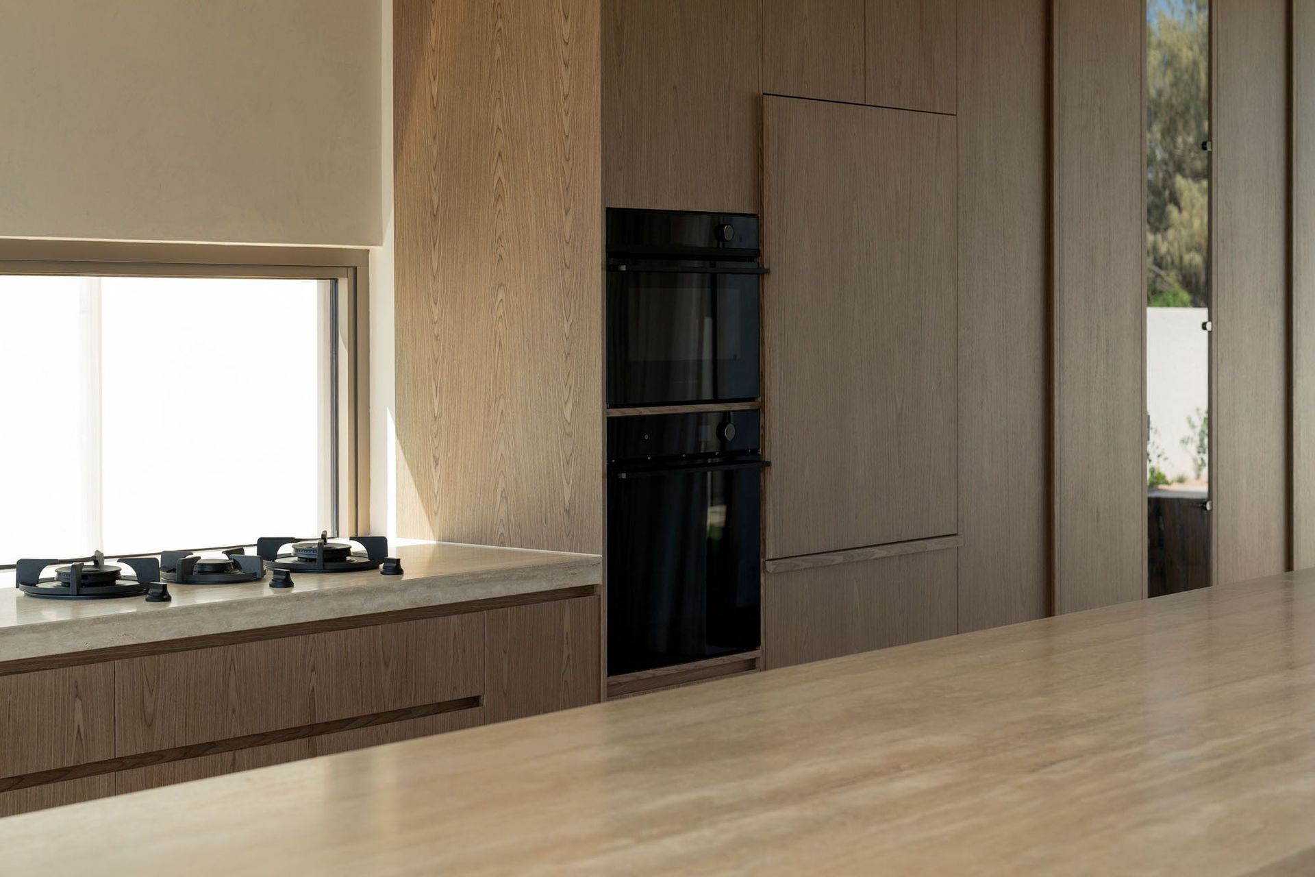 House on Pacific - Kitchen. Cooktop and integrated ovens set within timber joinery.