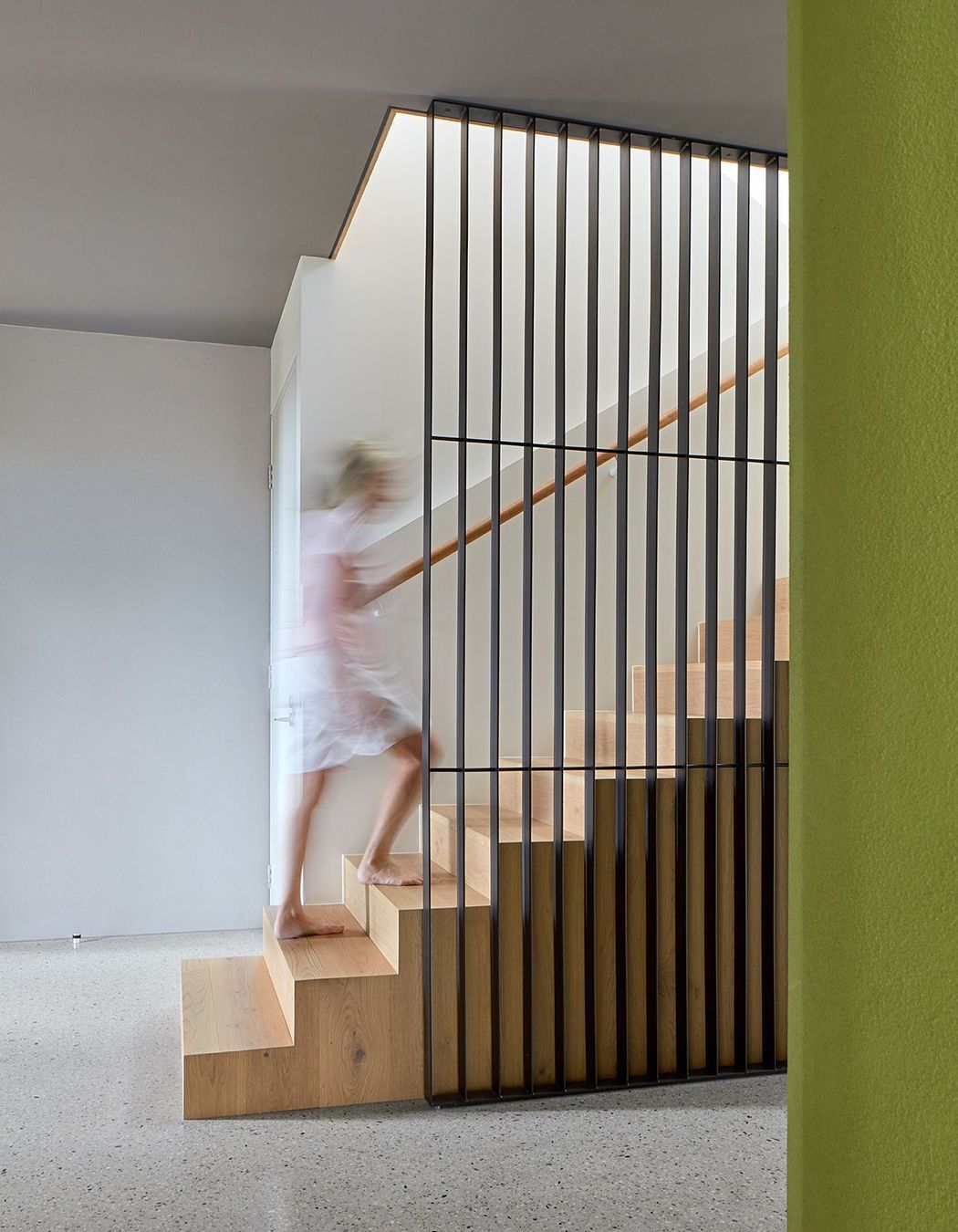 The interior scheme of the ground floor reflects the formal materiality – solid, grounded concrete terraces and rendered block balanced with polished-concrete screed floors and charcoal coloured ceilings. This broodiness is punctuated by the organic shape of the green rendered cellar – a shot of colour repeated throughout the house.