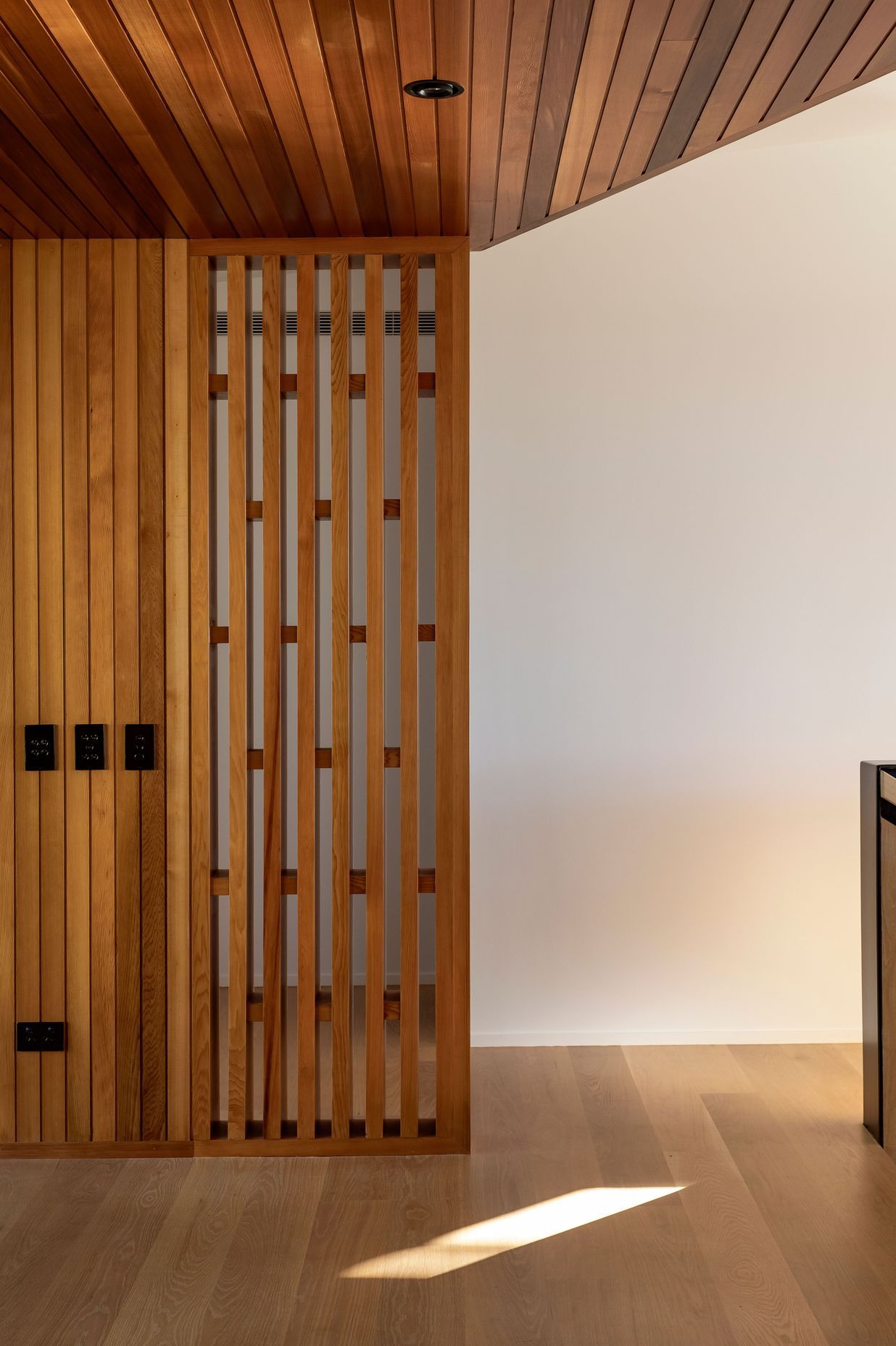 A timber screen provides privacy for the master suite, while allowing light in.