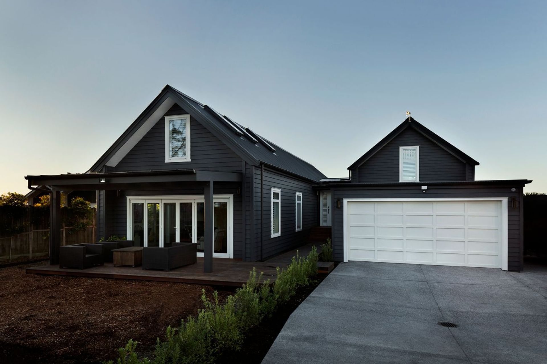 Gable forms and darkly painted weatherboards reference the bach that had previously stood on the site for more than 50 years.
