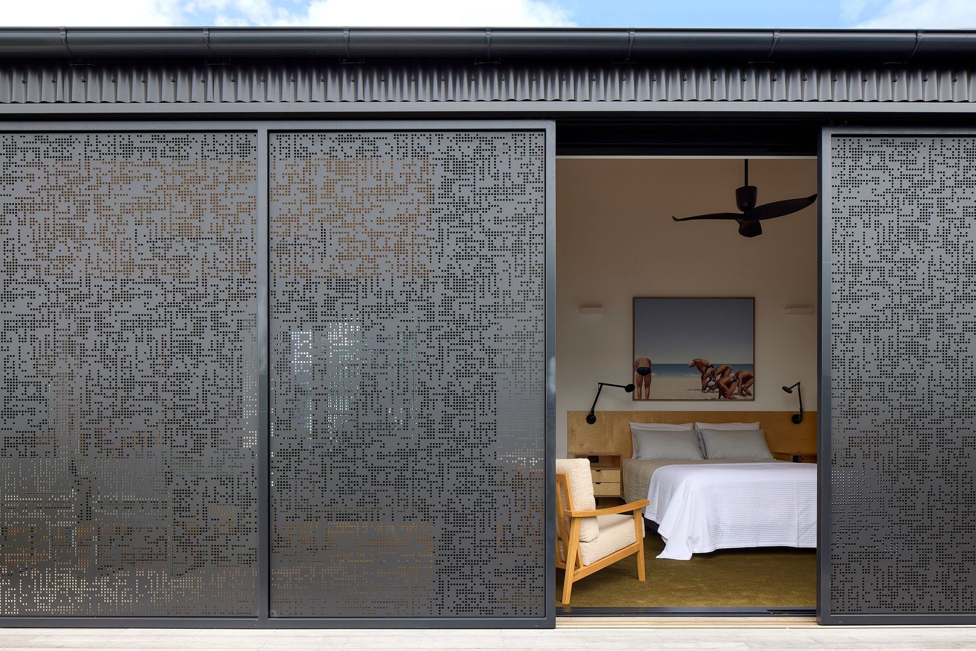 The operable perforated screens slide open to reveal the main bedroom while maintaining privacy and shelter. The adaptable façade responds to changing light, weather and patterns of occupation.