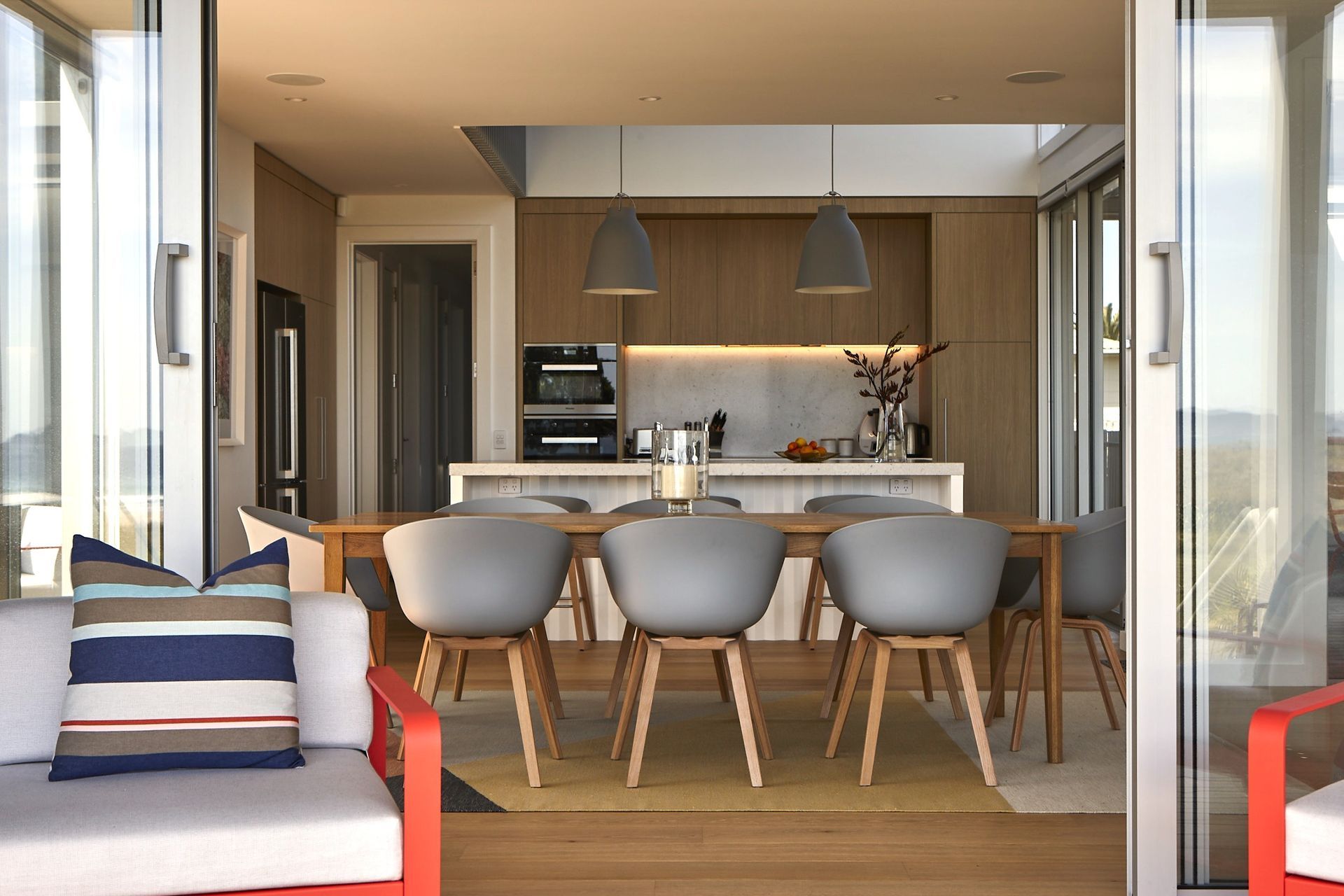 Standing on the front deck, large sliding doors reveal the generous open-plan kitchen, dining and living spaces. The seamless transition between indoors and outdoors captures the relaxed spirit of coastal living.
