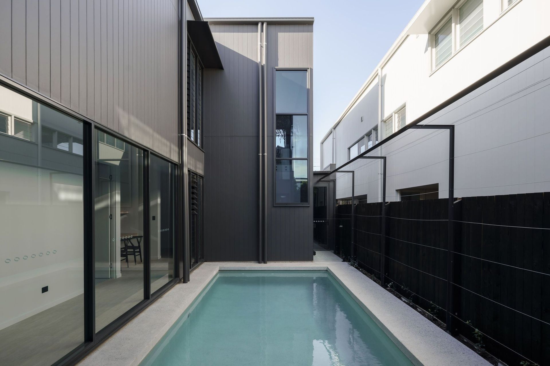Gilbert Residence - Pool. Lap pool running alongside the dark clad wall.