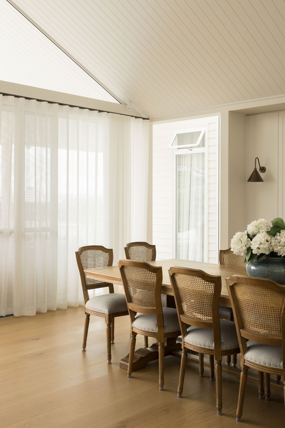 Euroa Farm - Dining Room. Dining table bathed in light from sheer curtained windows.