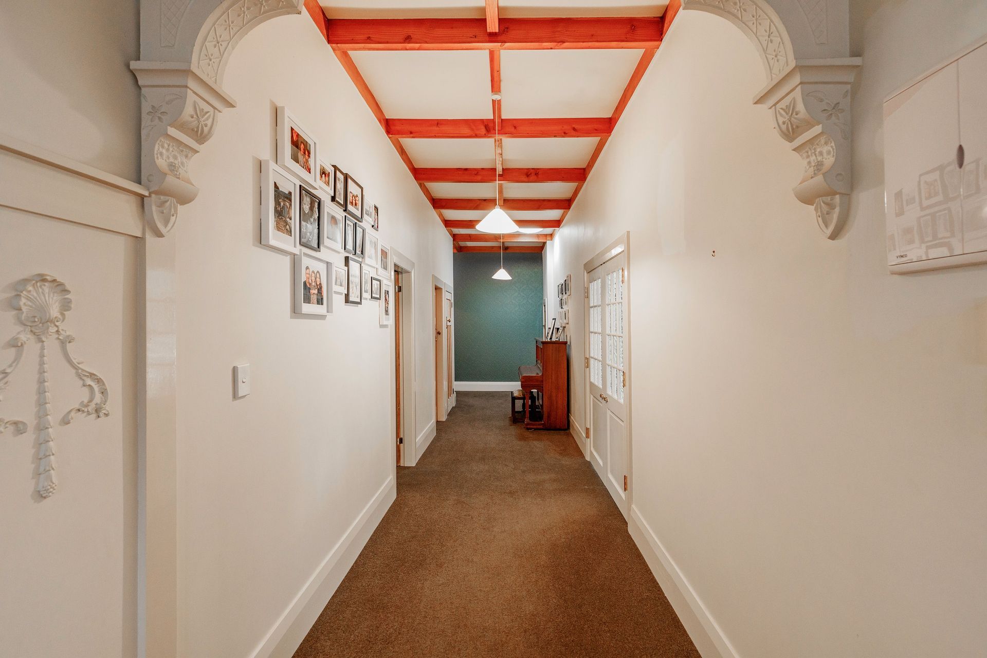 To visually elevate the space, a decorative dark blue wallpaper applied to the end of a long hallway, creates the illusion of a shorter space.  Aspiring Walls - Focus Collection - Paintables - RD80027 was painted in Resene Snapshot.