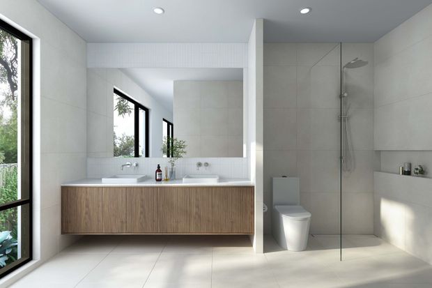 Bright contemporary bathroom with a floating timber-veneer double vanity, two integrated basins, large mirror, pale tiled walls and floor, and a frameless glass walk-in shower. A toilet and recessed wall shelving are visible on the right, with tall black-framed windows bringing in greenery and natural light.