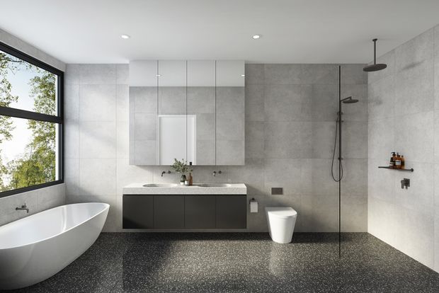 Contemporary minimalist bathroom with a freestanding white bathtub beside large black-framed glazing, a floating dark vanity with integrated basin and mirrored cabinet, wall-mounted fixtures, and a frameless walk-in shower. Large-format grey wall tiles contrast with a dark terrazzo-like floor, creating a clean, refined monochrome interior.