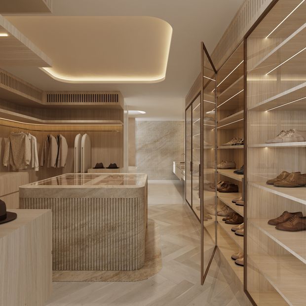 A refined walk-in wardrobe with warm timber cabinetry, extensive open shelving, glass-fronted shoe storage, hanging rails, and a central island with a stone benchtop and fluted vertical detailing. Soft integrated lighting, curved ceiling elements, and herringbone timber flooring create a calm, luxurious dressing space.